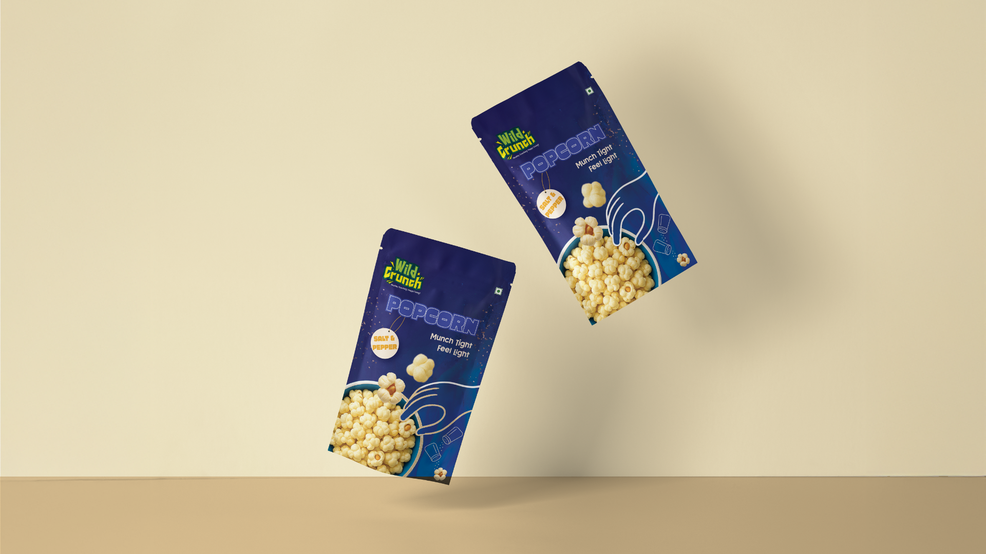 Two Salt and Pepper popcorn pouches floating against a cream wall